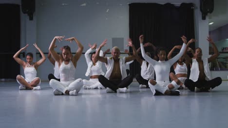 multi-ethnic group of fit male and female modern dancers practicing dance routine