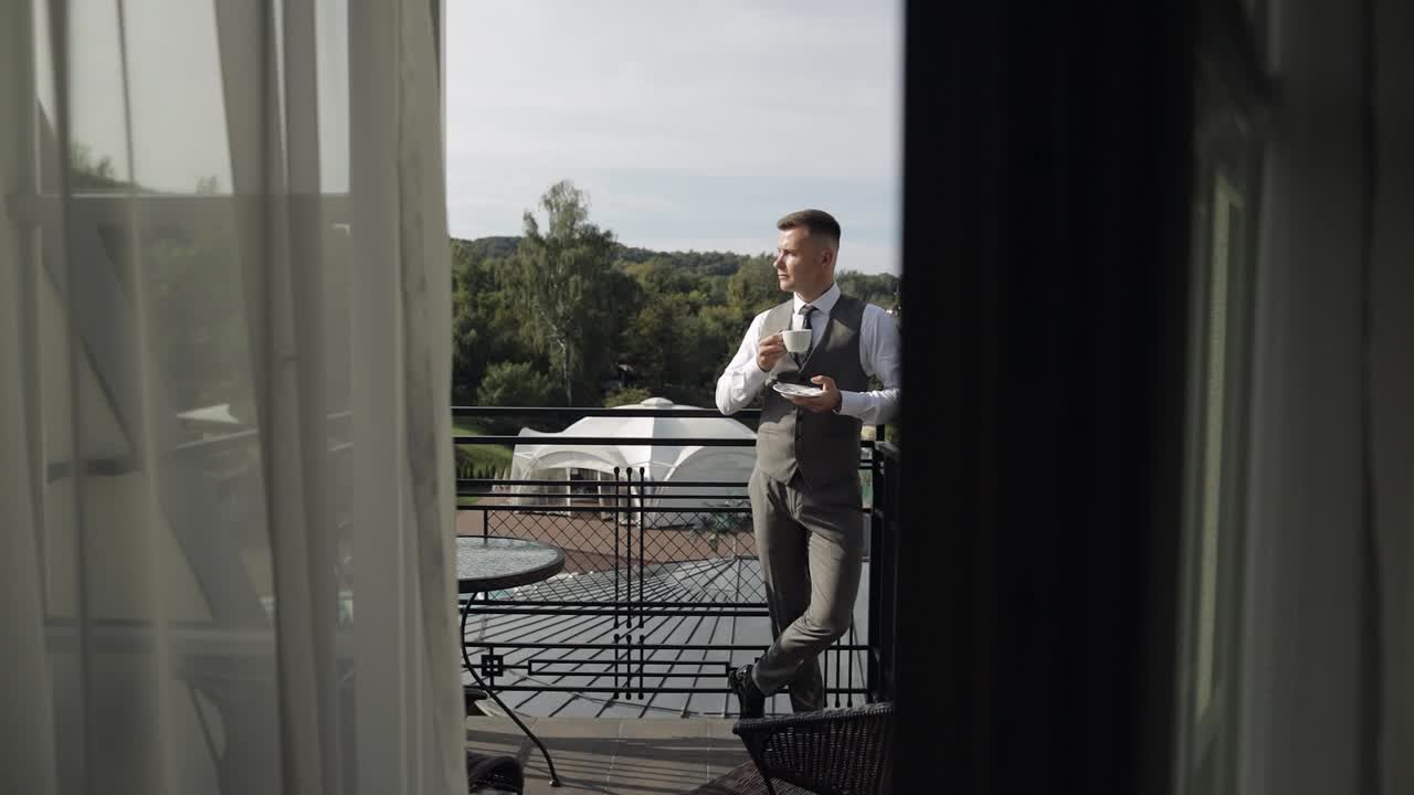 hombre en un traje disfrutando de su café de la mañana en un balcón con una vista