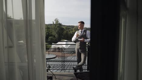 man in a suit enjoying his morning coffee on a balcony with a view