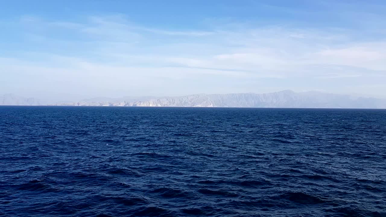 하늘에 있는 바다와 구름의 풍경, 지평선에 있는 산과 바다, 바다 위의 은 날씨에 구름이 있는 파란 하늘.