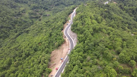 An aerial view showing a winding road through the mountains and forests in the Clongop area, Gunung Kidul, Yogyakarta.