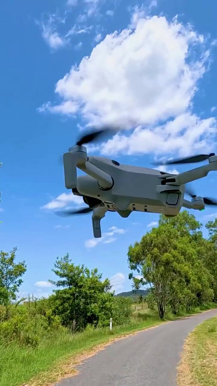 Un drone decolla vicino a eucalipti sotto un cielo sereno