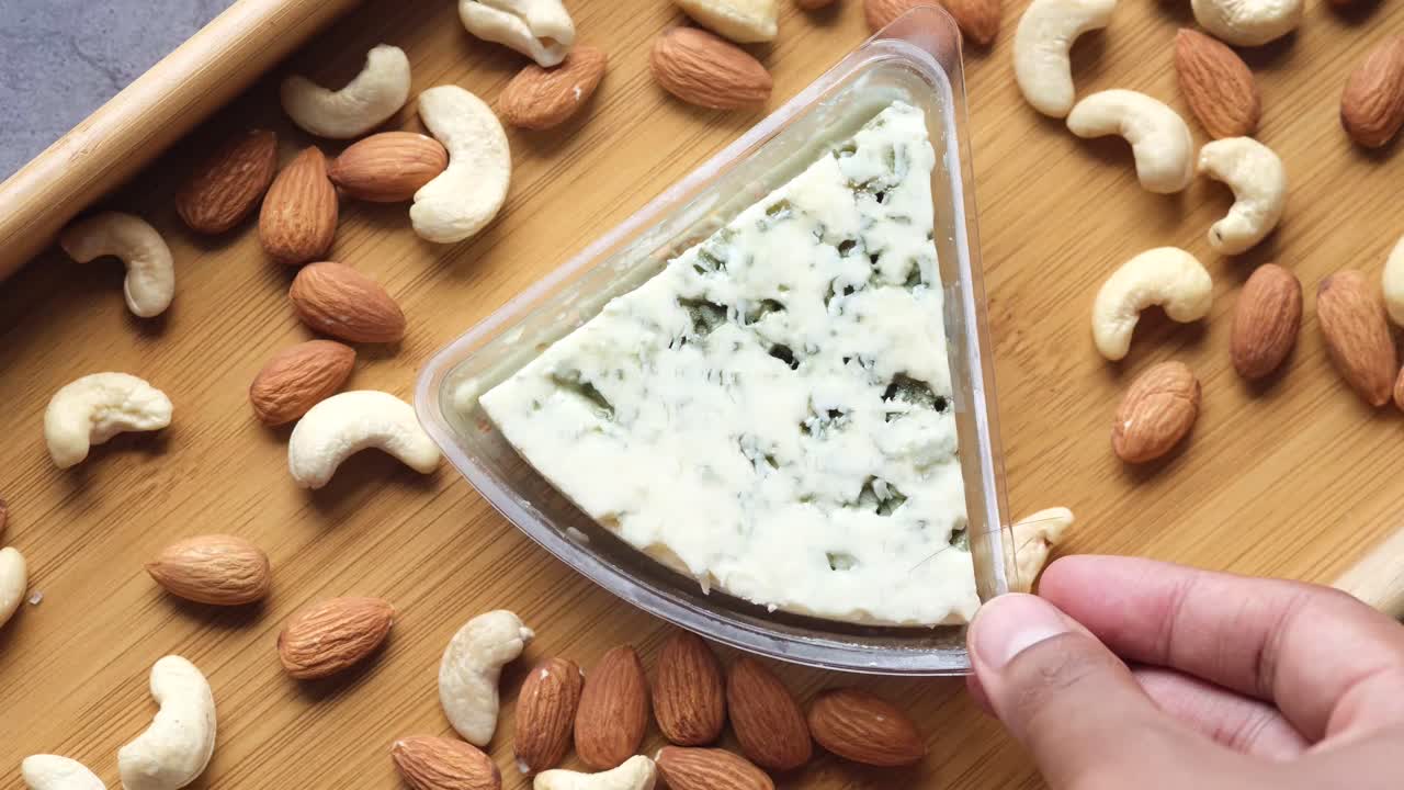 나무 트레이에 견과류와 함께 파란 치즈