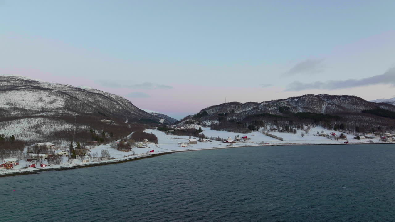 cielo iluminado de la noche polar en noruega, casas en la costa cubiertas de nieve