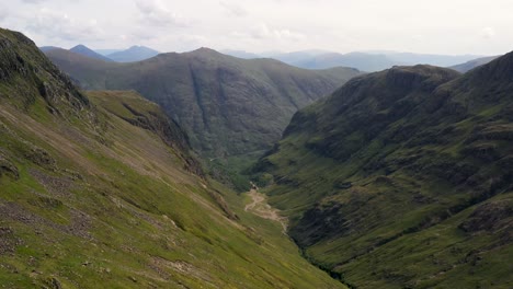 Eine-Reibungslose-Und-Dramatische-Luftaufnahme,-Die-Ein-Majestätisches-Bergtal-Im-Schottischen-Hochland-Hinunterfährt-|-Das-Verlorene-Tal,-Glencoe,-Schottland-|-Aufnahme-In-4k-Mit-30-Fps