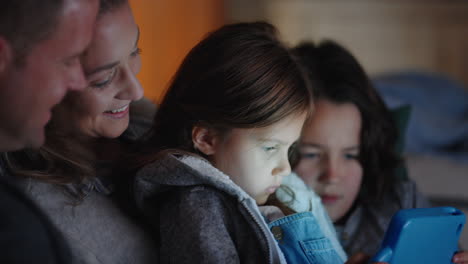 family using tablet computer little girl watching entertainment with mother and father on touchscreen technology enjoying relaxing before bedtime 4k