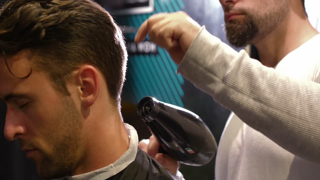 hombre secándose el cabello con un secador de pelo