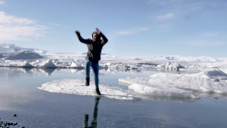 Junger-Männlicher-Reisender-Springt-In-Zeitlupe-Von-Einer-Eisscholle-In-Der-Wunderschönen-Gletscherlagune-Islands