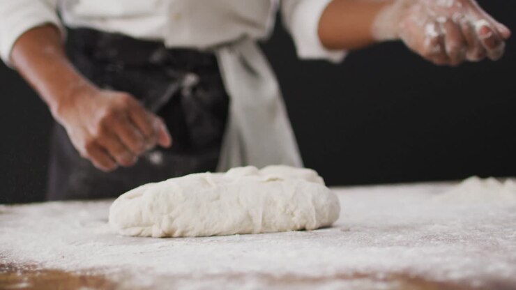 Video of cook throwing flour on the table on black background