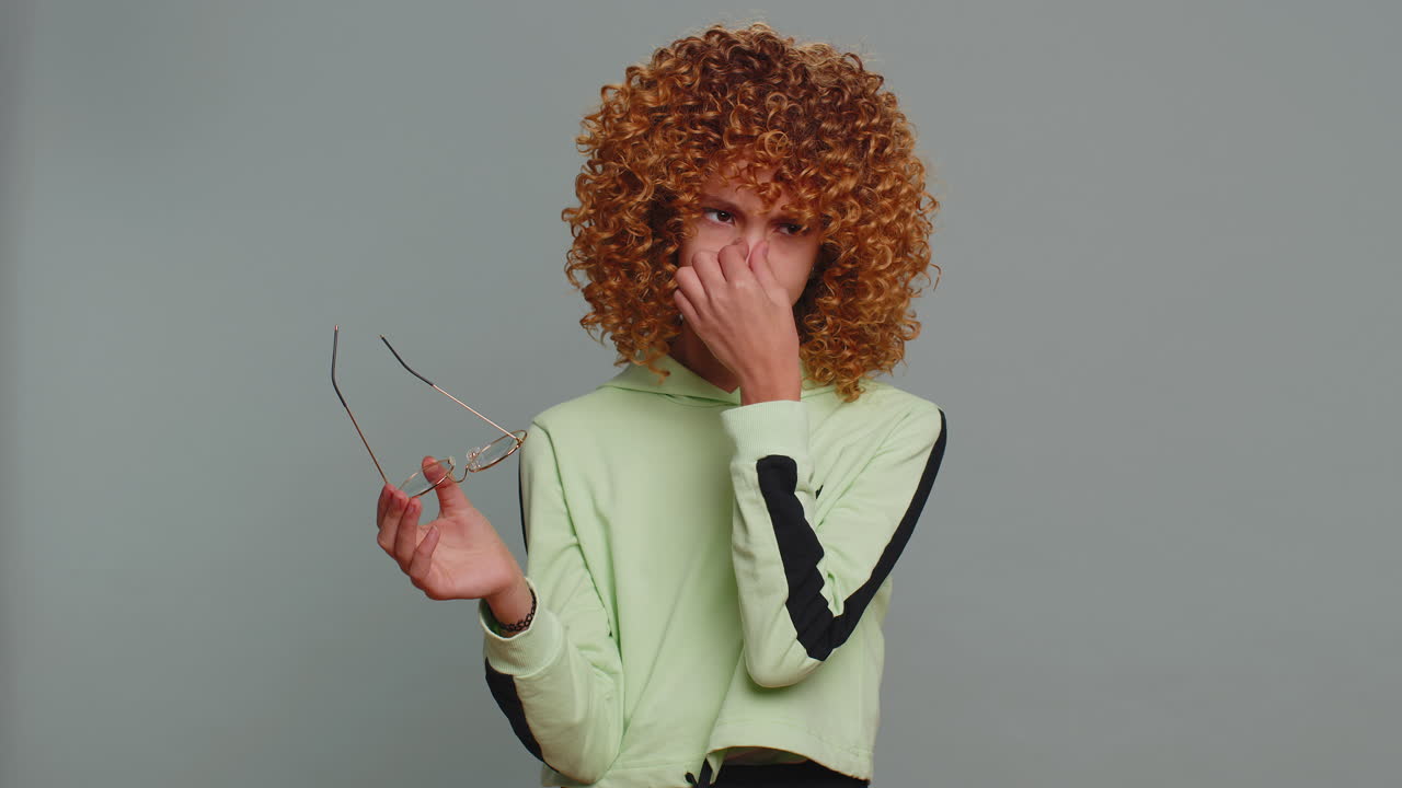 Exhausted tired girl takes off glasses feeling eyes pain overwork burnout from long hours working