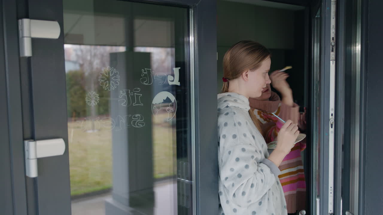 Woman drawing on a glass door