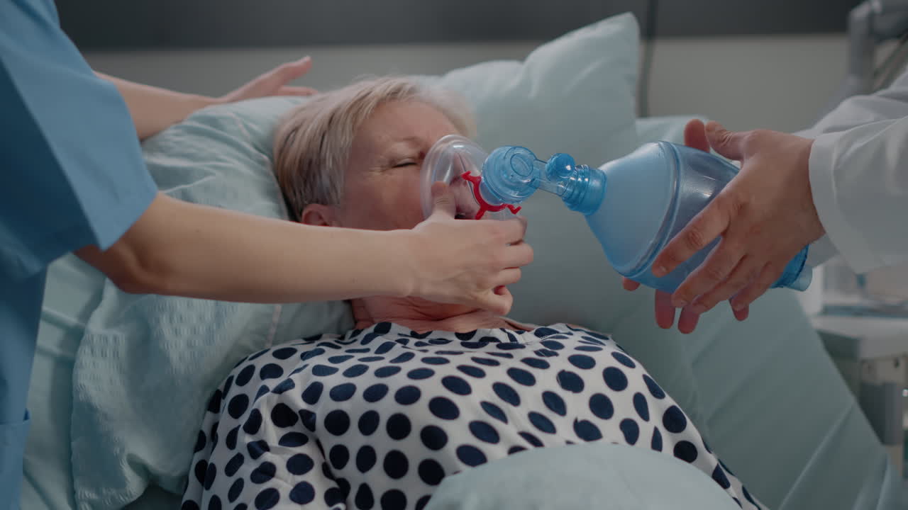 Close up of hyperventilating woman in hospital ward bed