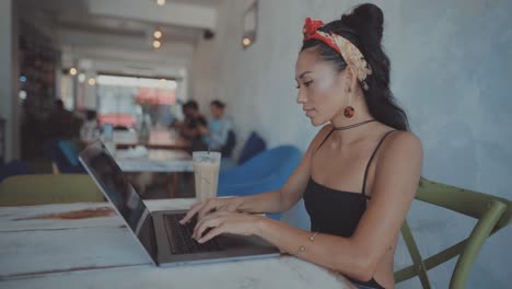 woman working on laptop in a cafe