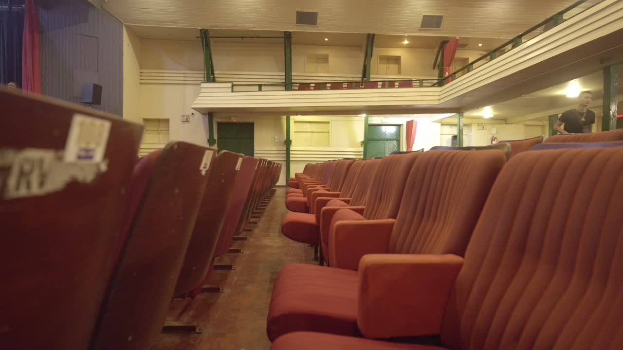 Empty red seats in Thalia Theatre with yellow lights, big building