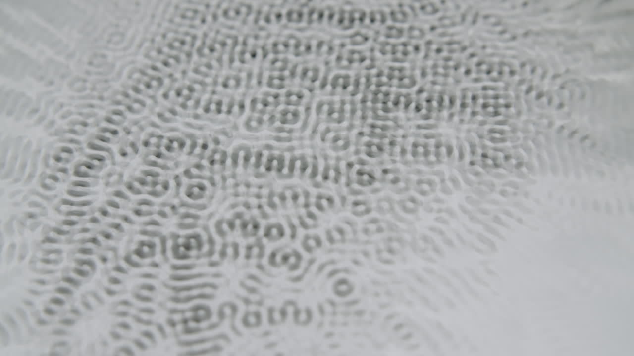 밝은 회색 배경에 작은 추상 사이매틱 형태