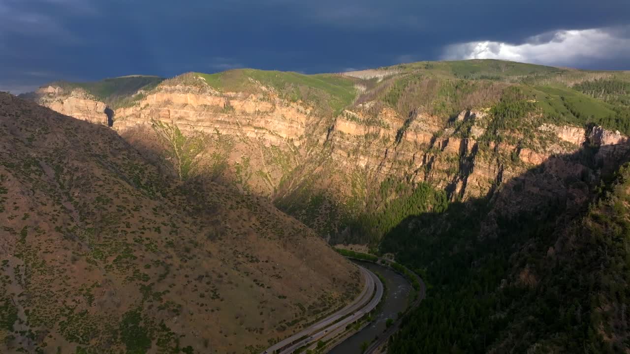 Summer Glenwood Canyon Scenic Drive Glenwood Springs Colorado River interstate i70 highway west east car traffic sun on Grand Mesa cliffside late afternoon dark rain thunderstorm clouds backwards up
