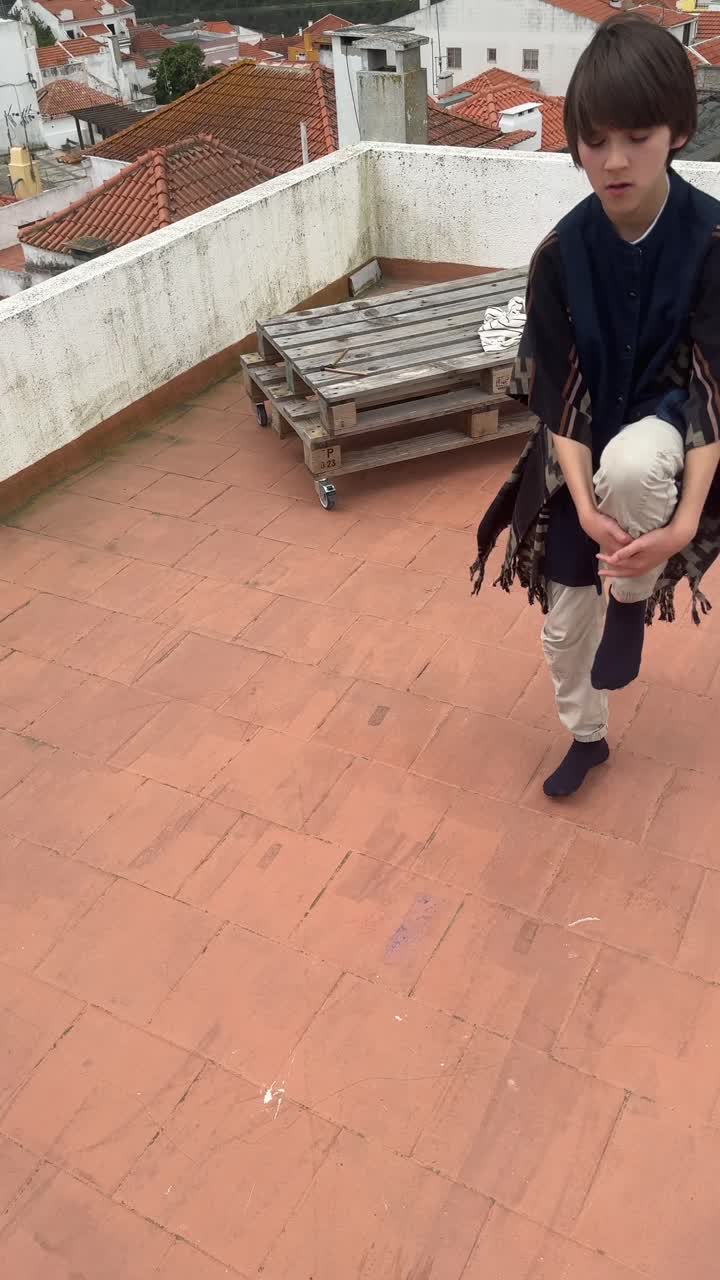 Boy carrying a backpack on a rooftop