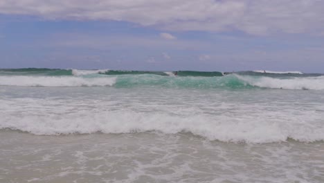 Schaumige-Wellen-Mit-Surfern-Im-Sommer-Am-Hauptstrand-Der-South-Gorge-In-North-Stradbroke-Island,-Queensland,-Australien