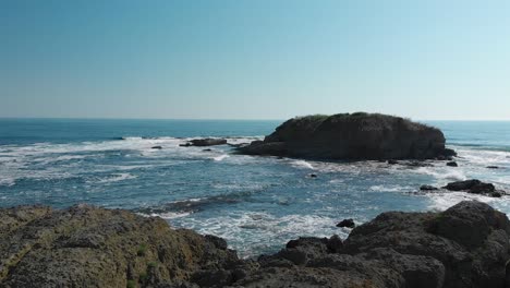 Flying-Towards-Black-Rocks-With-Splashing-Blue-Sea-Water-Near-The-Shore-In-Lozenets,-Burgas,-Bulgaria