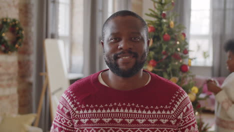 portrait of positive black man at home on christmas day