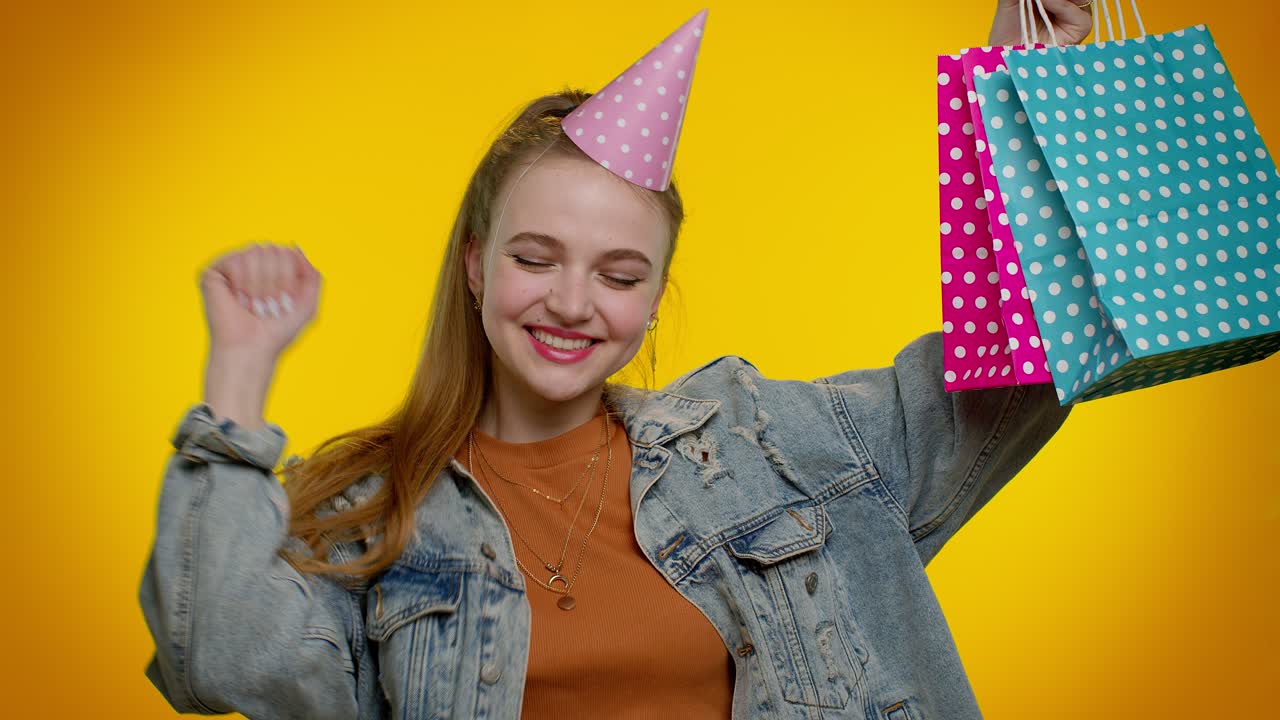 Ragazza adolescente che mostra borse della spesa, pubblicizzando sconti, prezzi bassi, shopping durante il Black Friday