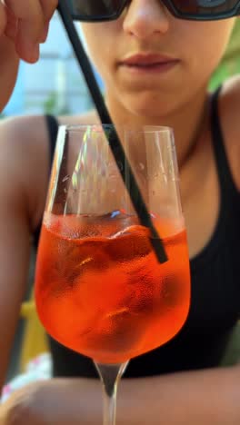 frau, die aperol spritz trinkt