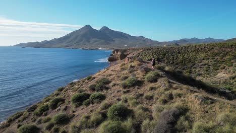 woman hike with dog in cabo de gata national park, almeria, andalusia, spain - aerial