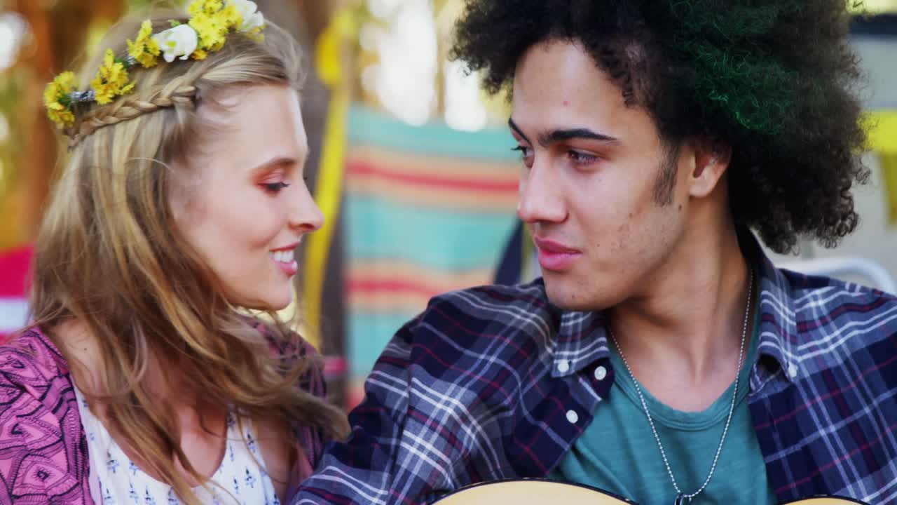 hombre tocando la guitarra para su mujer en el parque 4k