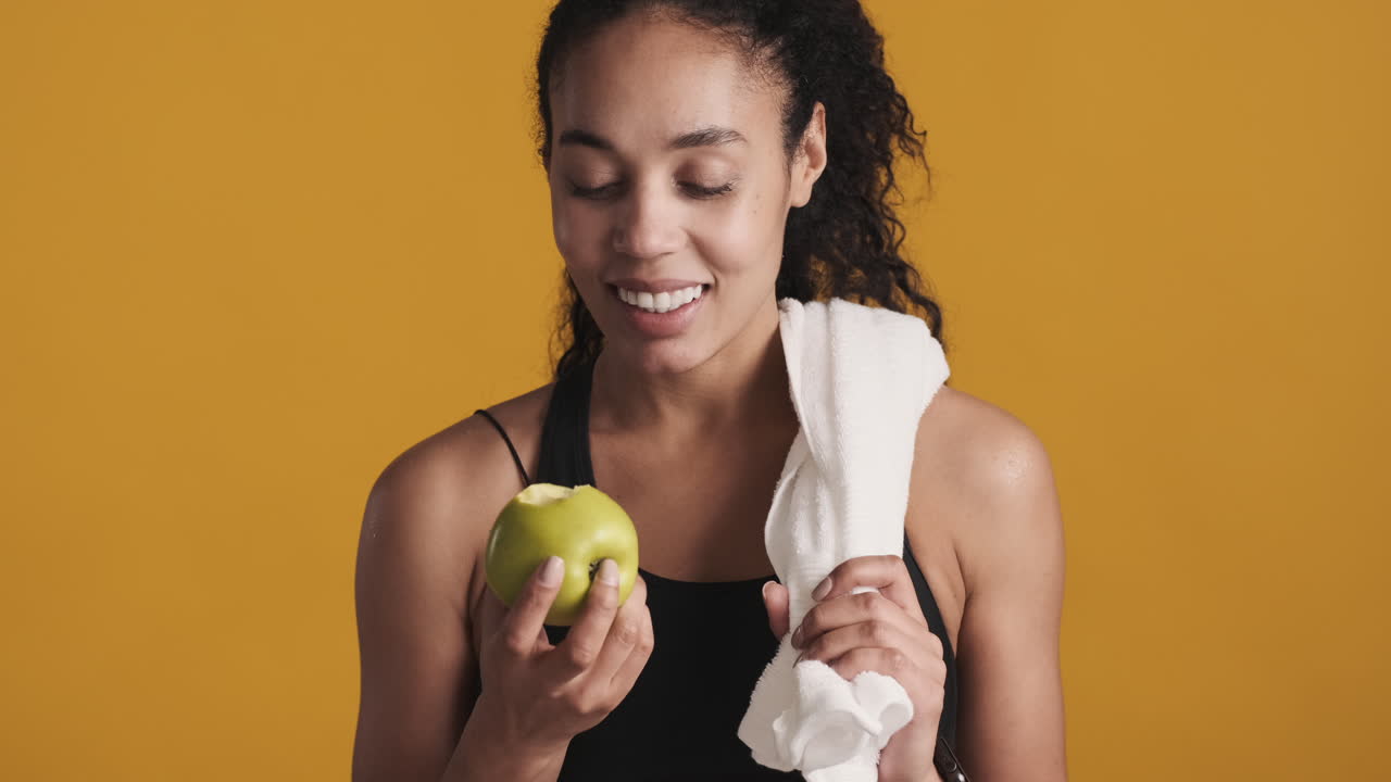 una mujer afroamericana feliz sobre un fondo amarillo.