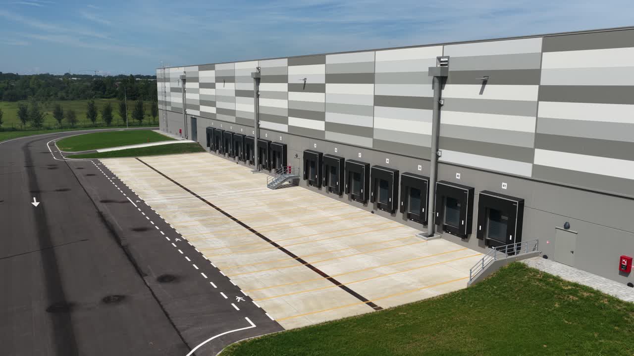 Modern truck loading bay at distribution center. Logistics infrastructure. Commercial shipping. Aerial close up drone video