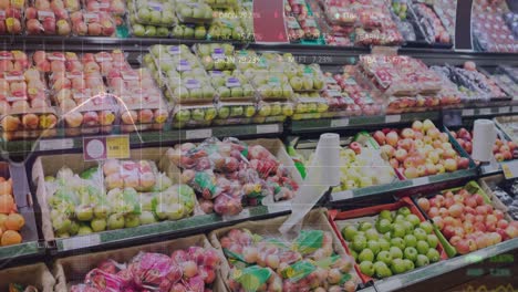 animation of stock market data processing against fresh fruits on the shelves at a grocery store