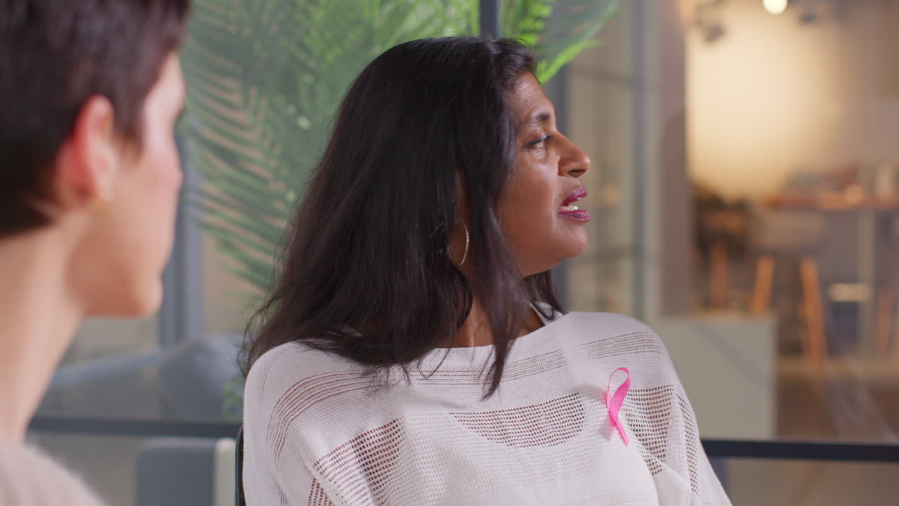 Mature Woman Wearing Pink Breast Cancer Awareness Ribbon Talking At Meeting Of Therapy Support Group For Cancer Treatment Patients 5