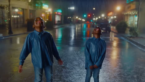 two boys enjoying the rain at night