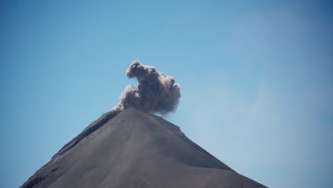 Ein-Plötzlicher-Ausbruch-Des-Vulkans-Fuego-Am-Mittag,-Der-Aschewolken-Vor-Einem-Minimalistischen-Himmelshintergrund-Einfängt