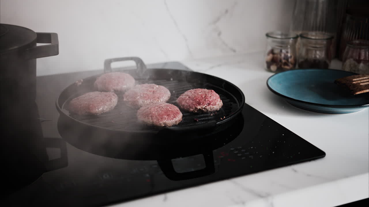 Burger patties being cooked on a grill pan