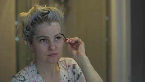 woman dyes her hair and eyebrows herself