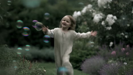 happy child playing with bubbles in a garden