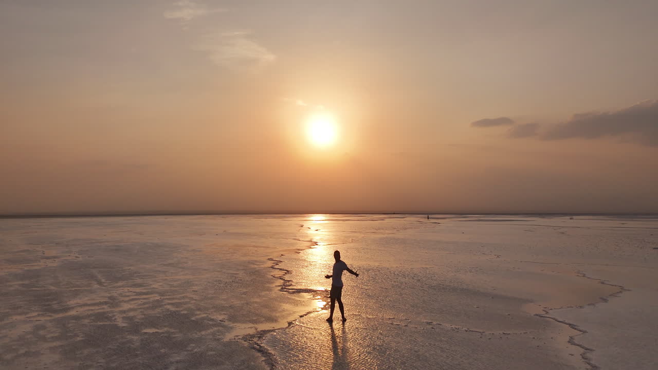 Vista aerea delle saline nella Depressione della Dancalia, dove vaste croste minerali bianche si estendono attraverso la regione dell'Afar in Etiopia. Persone che camminano sulle saline. Verso il sole.