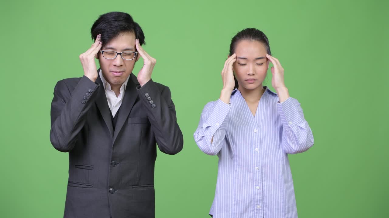 Young Asian business couple having headache together