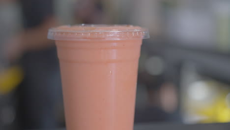 close up dolly in of a pink fruit smoothie