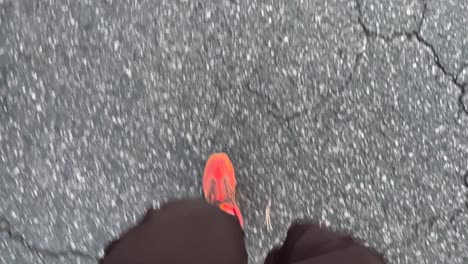 Man-walking-in-orange-hiking-boots-and-black-shorts-with-view-from-above-looking-down