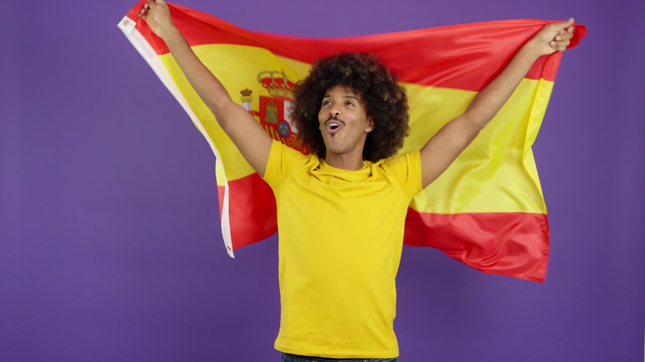 Man with afro hair celebrating with the Spanish flag