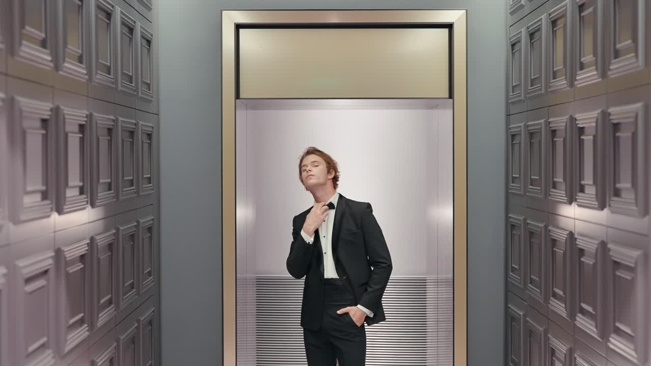 스모킹을 입은 남자가 엘리베이터에