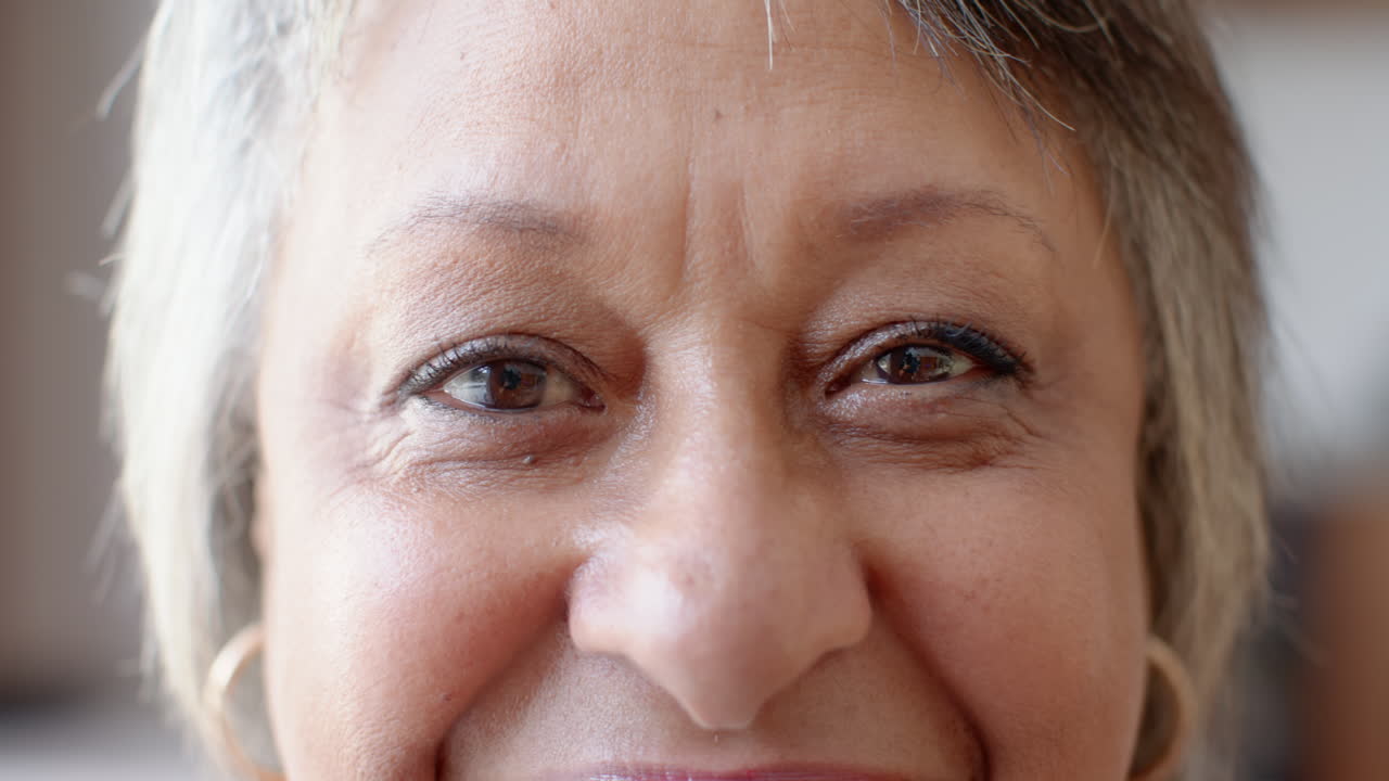 Smiling senior woman with short hair and earrings, enjoying her time, at home