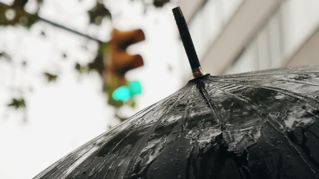 Business man tourist person with umbrella and raincoat on rainy european city street, lights reflecting, walking in Barcelona or Amsterdam during the rain