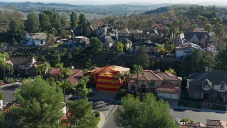 aerial approach of a large house that has been tented for termites in an affluent neighborhood in southern california