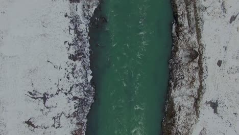 iceland in winter snowy river overhead slow scroll down drone 4k