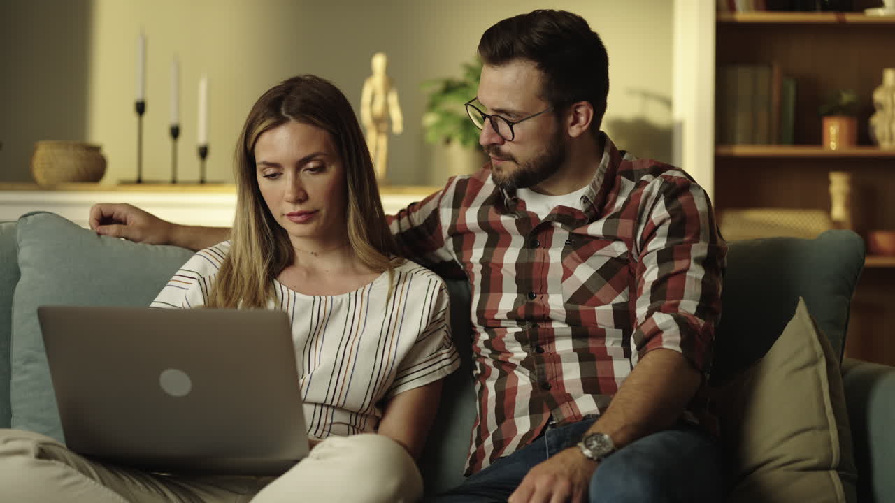 pareja usando una computadora portátil en casa
