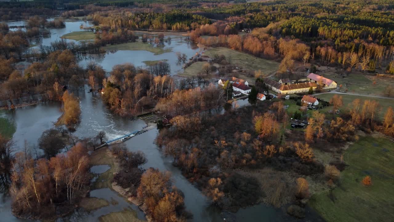 agua de un río con un dique que inunda el asentamiento cercano