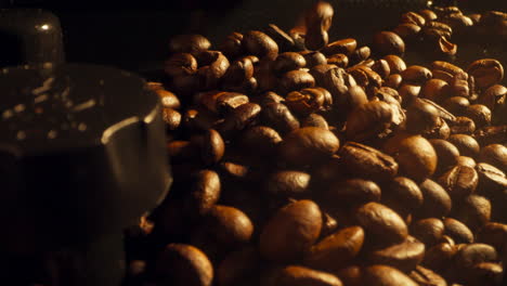 dolly in shot of coffee beans pouring down on a coffee machine, slow motion, close up